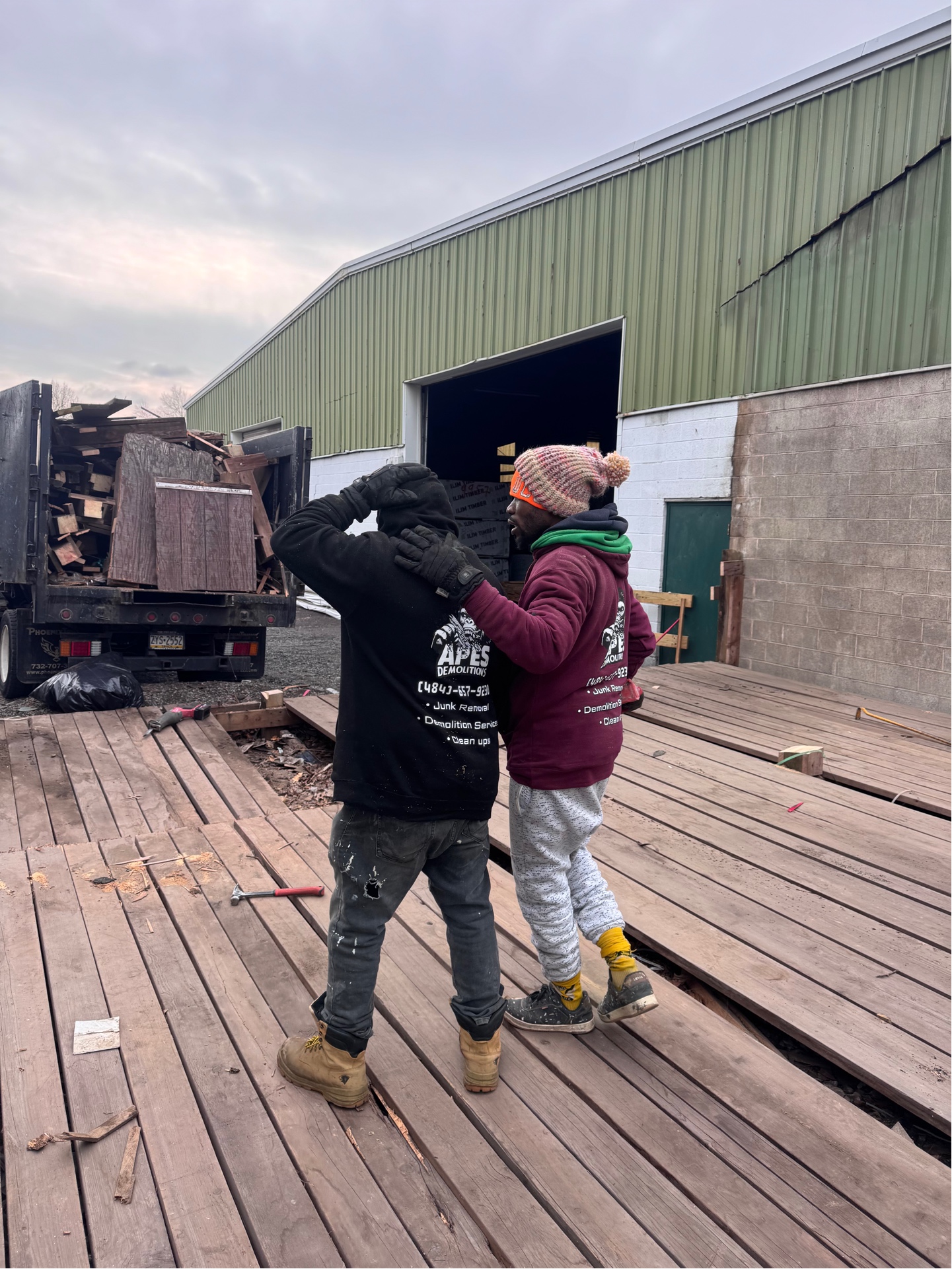 APES Demolitions crew members in branded hoodies working on a demolition project